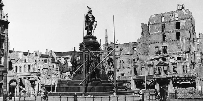 Foto: Leipzig – Siegesdenkmal – Vor den Ruinen von Alter Waage und Kochs Hof (1945)